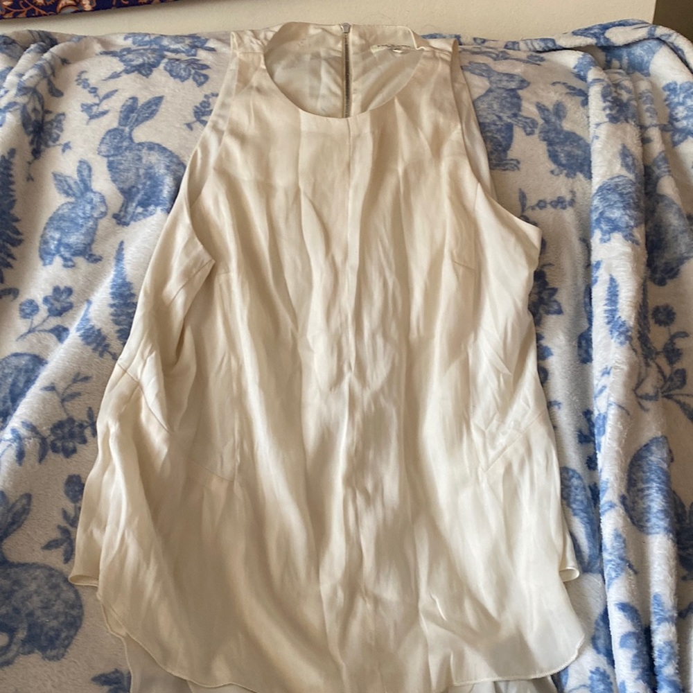 Off white tank top, zipper on back as well as a longer back or “tail”